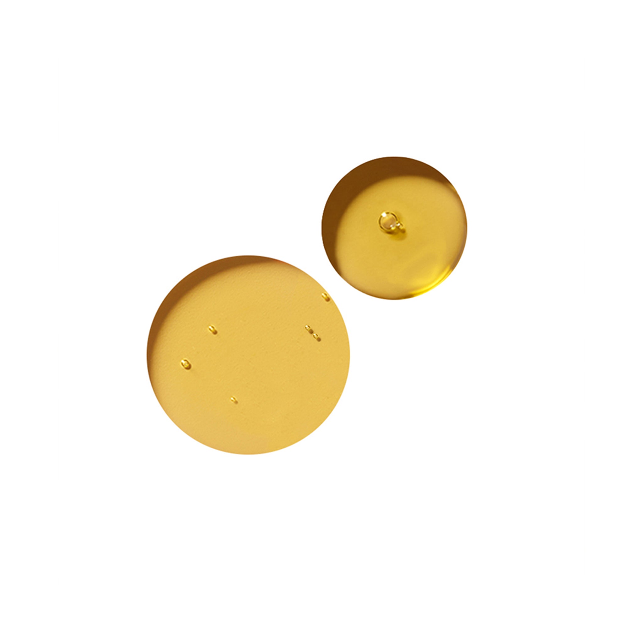True Botanicals | Pure Radiance Body Oil | Swatch Image - two golden oil droplets with a glossy, fluid texture on a white background