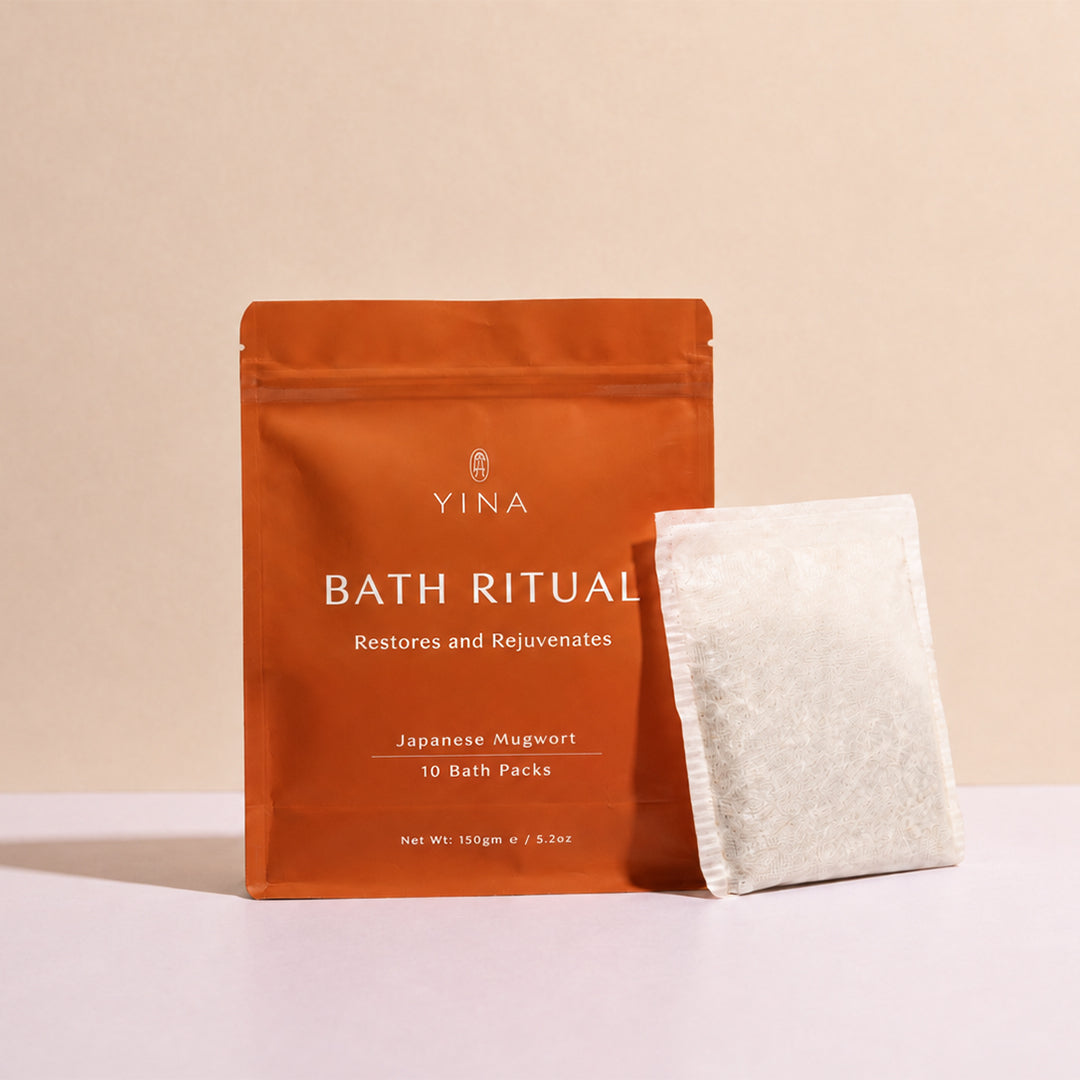 YINA | Bath Ritual | Lifestyle Image - orange pouch displayed with a white bath pack against a beige background