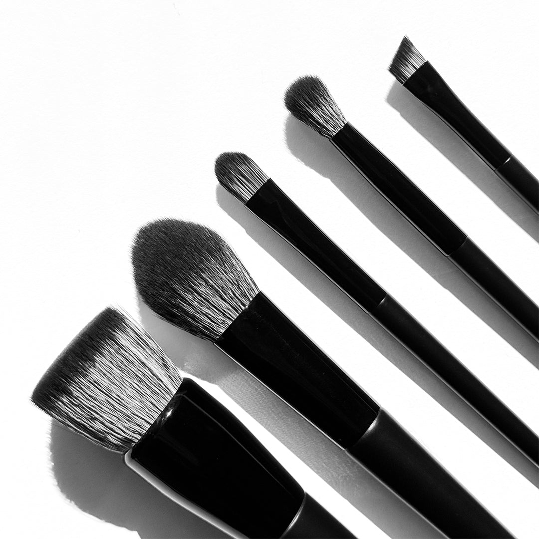 withSimplicity | Brush Essentials Kit | Close-Up Image - five black makeup brushes with different bristle shapes on a white background