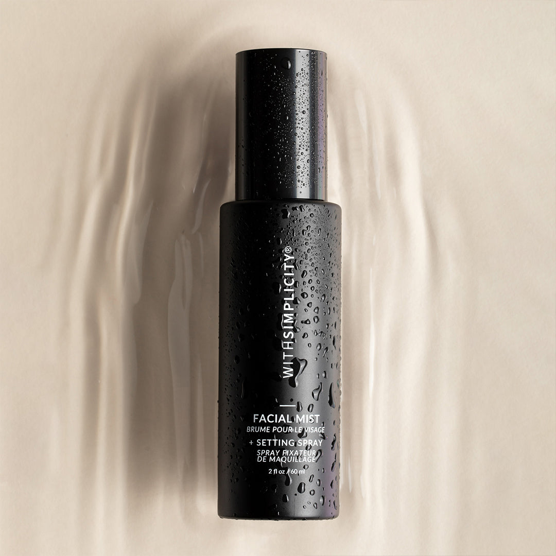 withSimplicity | Facial Mist + Setting Spray | Creative Shot - black spray bottle with water droplets on a soft beige background